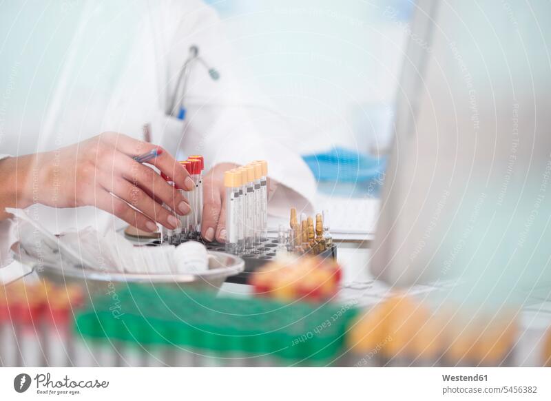 Close-up of lab technician with test tubes and rack in laboratory woman females women working At Work science sciences scientific workplace work place