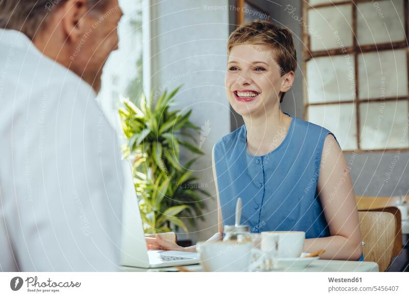 Businessman and businesswoman having a meeting in a cafe Business Meeting business conference talking speaking smiling smile Meetings business world