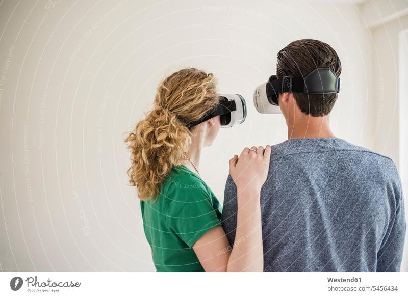 Young couple in empty apartment wearing VR glasses twosomes partnership couples Virtual Reality Glasses Virtual-Reality Glasses virtual reality headset