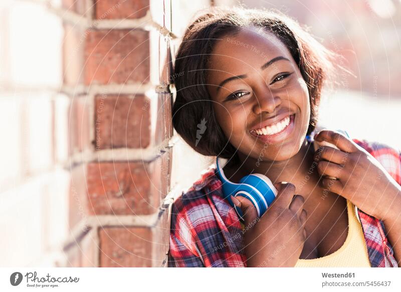 Portrait of a happy young woman with headphones around her neck laughing Laughter headset happiness females women portrait portraits cheerful gaiety Joyous glad