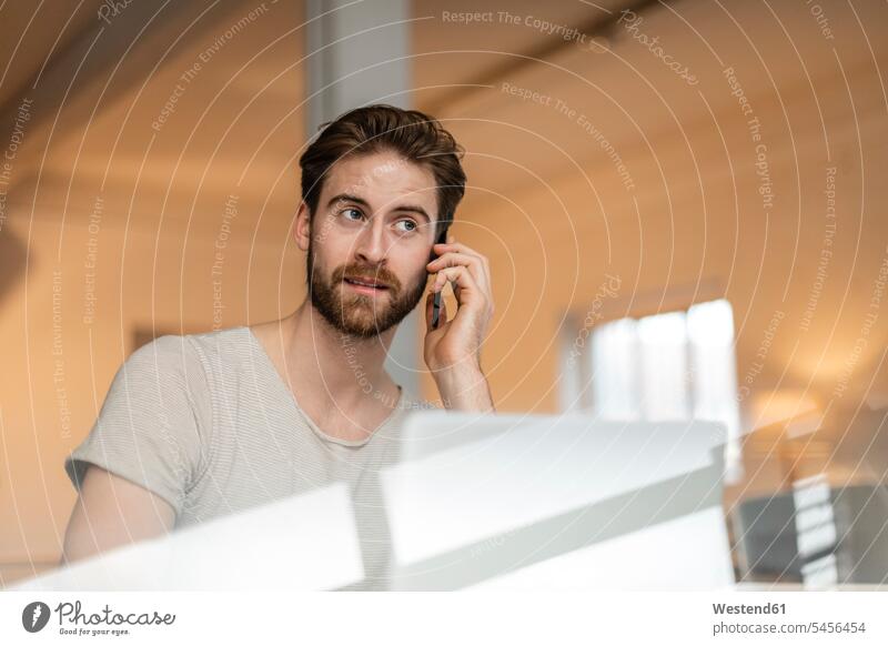 Portrait of young man on the phone in a loft call telephoning On The Telephone calling men males telephone call Phone Call using phone Using Phones Adults