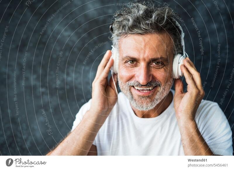 Mature man smiling, wearing headphones music headset smile listening mature men mature man portrait portraits males Adults grown-ups grownups adult people
