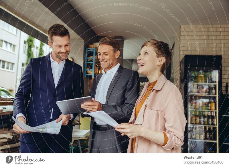 Woman and two businessmen discussing plans in a cafe smiling smile business partner associates business associates business partners Planning planning planned