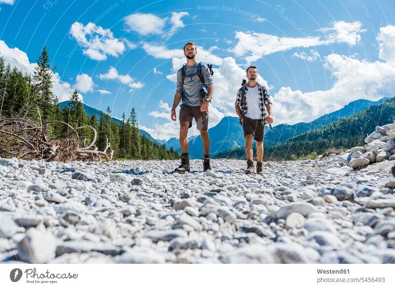 Germany, Bavaria, two hikers walking in dry creek bed friends wanderers friendship hiking going river bed riverbed hiking tour walking tour excursion Getaway