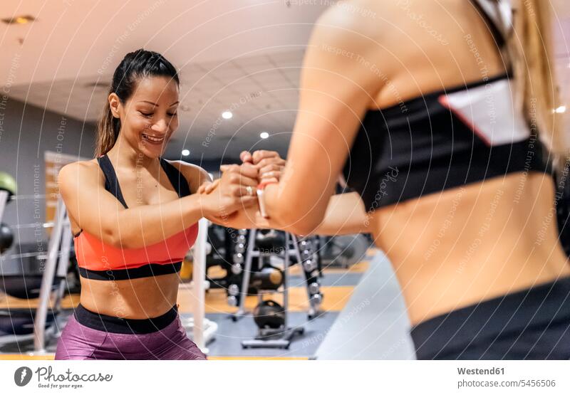 Two women working out in gym exercising exercise training practising woman females Adults grown-ups grownups adult people persons human being humans