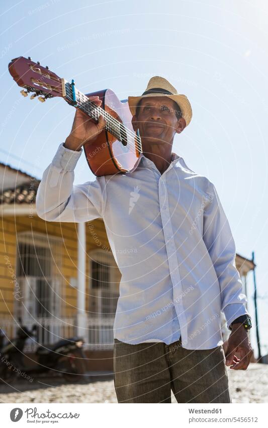 Cuba, portrait of man with guitar on his shoulder street musician street musicians men male adults males guitars Adults grown-ups grownups people persons