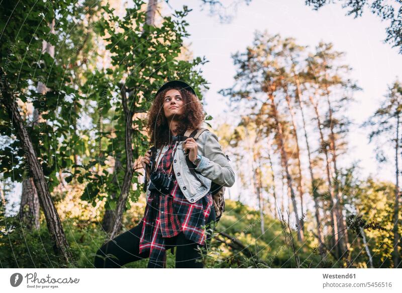 Portrait of teenage girl with camera and backpack in nature Teenage Girls female teenagers forest woods forests Teenager Teens people persons human being humans