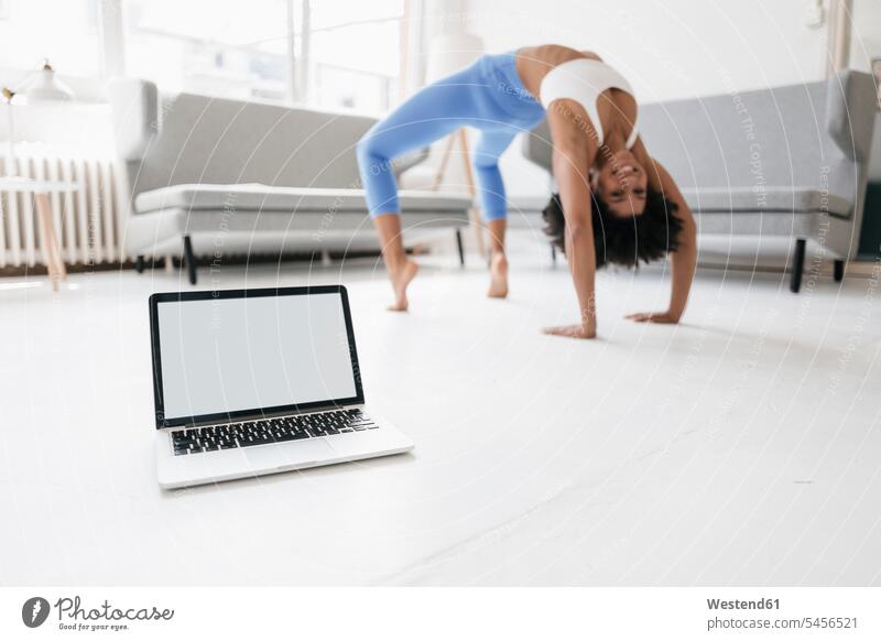 Young woman practising yoga with laptop by her side Yoga online fit Laptop Computers laptops notebook learning practicing practice practise exercise exercising