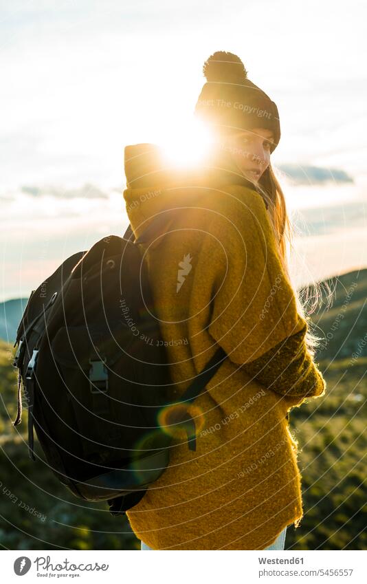 Portrait of young woman with backpack in nature at sunset females women Adults grown-ups grownups adult people persons human being humans human beings rucksacks