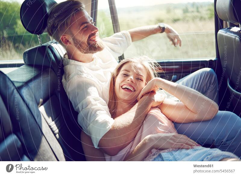 Happy young couple relaxing in car Fun having fun funny automobile Auto cars motorcars Automobiles laughing Laughter twosomes partnership couples happiness