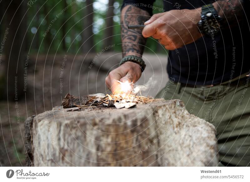 Man igniting a fire on tree stump in the forest tattoo tattoos lighting man men males woods forests Tree Stump Tree Stumps tattooed style stylish Adults