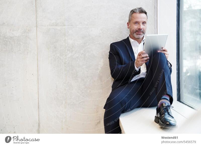 Portrait of smiling businesssman using tablet at the window Businessman Business man Businessmen Business men digitizer Tablet Computer Tablet PC