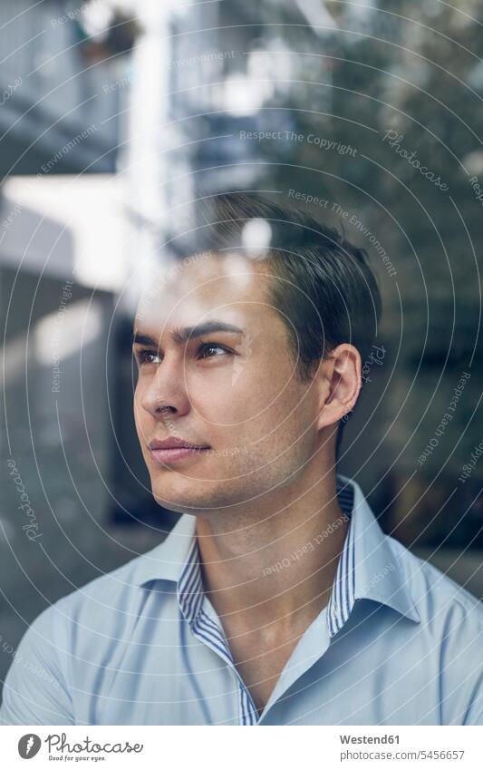 Portrait of young businessman behind glass pane in office Businessman Business man Businessmen Business men window windows portrait portraits business people