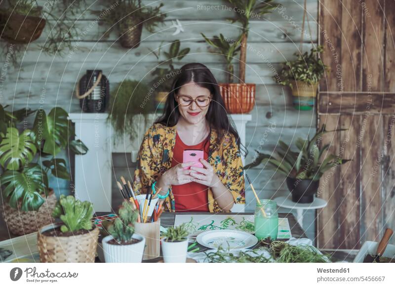 Young woman taking pictures of painted plants with her smartphone aquarelle Watercolor Painting Smartphone iPhone Smartphones mobile phone mobiles mobile phones