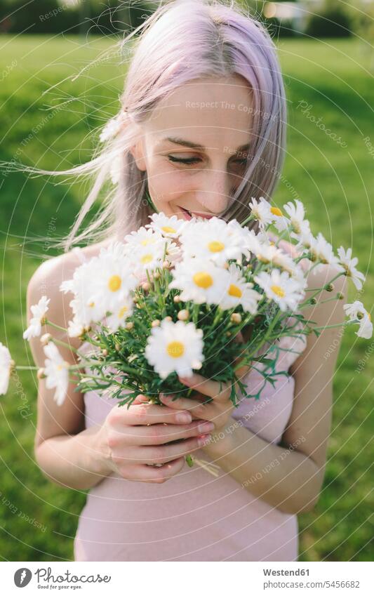 Happy woman holding bunch of daisies portrait portraits females women Adults grown-ups grownups adult people persons human being humans human beings laughing