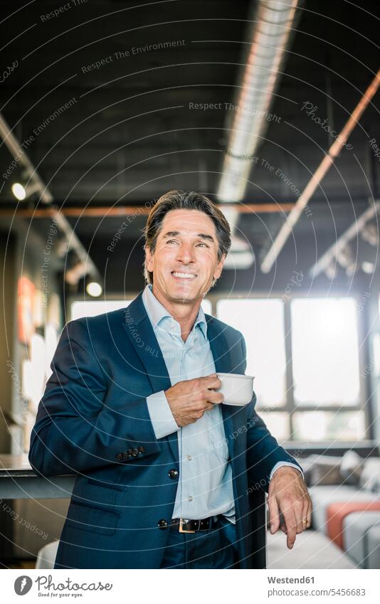 Smiling businessman in office with cup of coffee Coffee Cup Coffee Cups smiling smile Businessman Business man Businessmen Business men offices office room