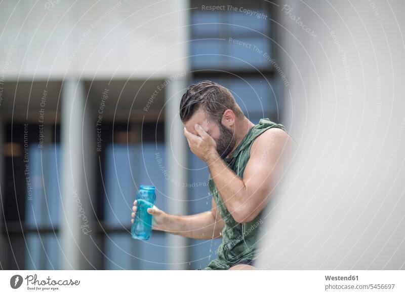 Athlete taking a water break in the city exercising exercise training practising man men males Water Adults grown-ups grownups adult people persons human being