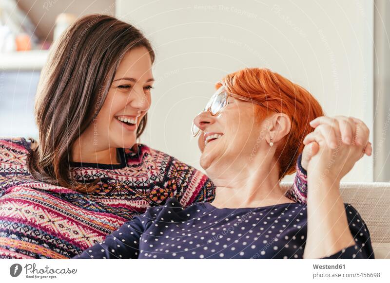 Happy adult daughter with mother at home mommy mothers ma mummy mama daughters laughing Laughter happiness happy woman females women parents family families