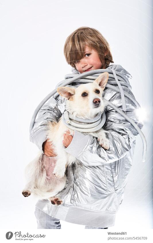 Portrait of a boy wearing fancy dress carrying dog boys males fancy-dress costume Fancy Dress Costumes disguise costumes playing holding dogs Canine child
