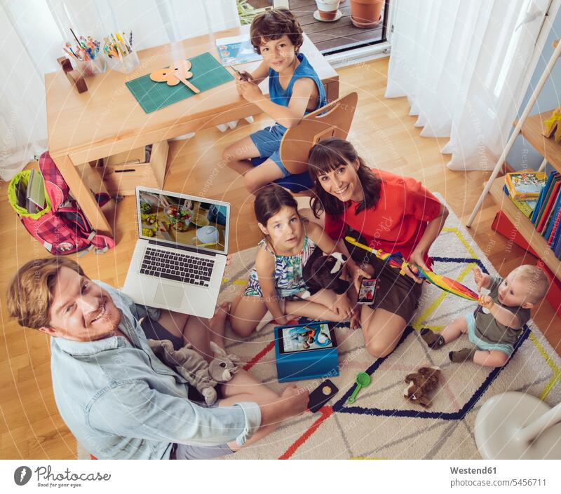 Portrait of happy family in children's room portrait portraits families smiling smile playing people persons human being humans human beings sitting Seated
