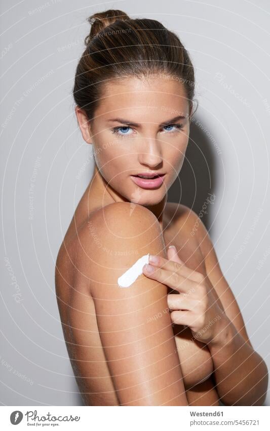 Portrait of beautiful young woman applying skin cream on her arm females women portrait portraits attractive pretty good-looking Attractiveness Handsome Beauty