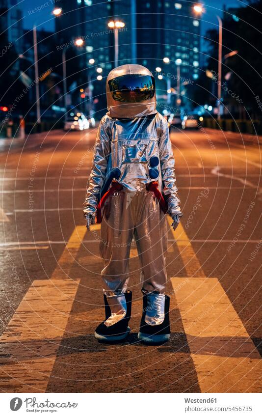 Spaceman standing on a street in the city at night town cities towns by night nite night photography astronaut astronauts spaceman spacemen road streets roads