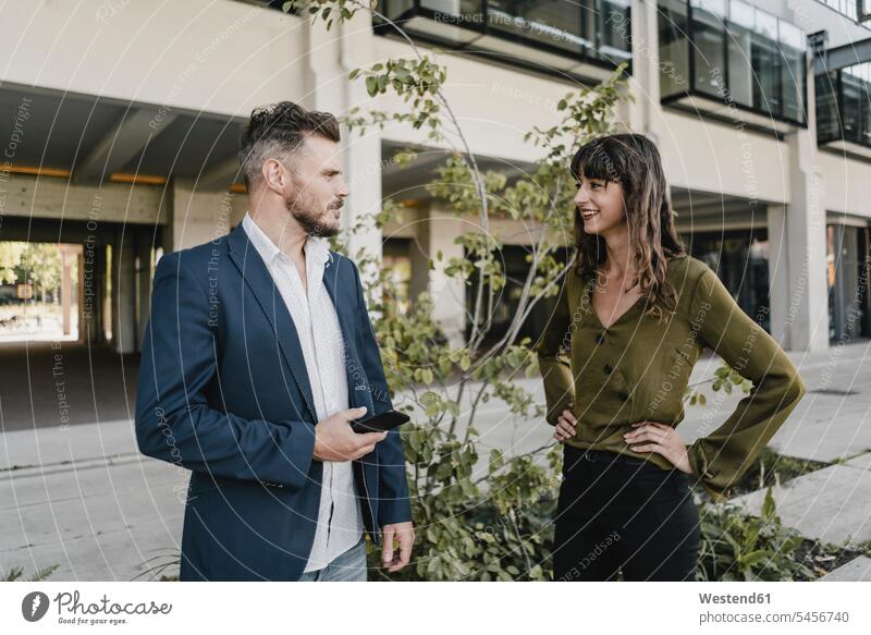Businessman and casual businesswoman talking outdoors human human being human beings humans person persons caucasian appearance caucasian ethnicity european 2