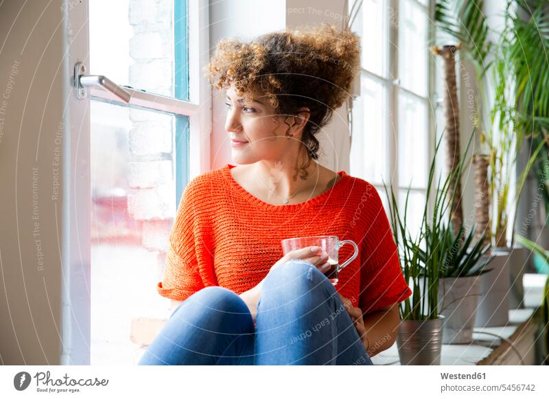 Woman with a coffee looking out of window in office Occupation Work job jobs profession professional occupation business life business world business person