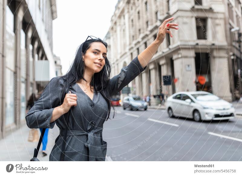 Woman in the city hailing a taxi, London, UK human human being human beings humans person persons caucasian appearance caucasian ethnicity european 1