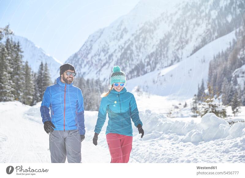 Couple walking in snow-covered landscape going landscapes scenery terrain snow covered covered in snow snowy couple twosomes partnership couples people persons