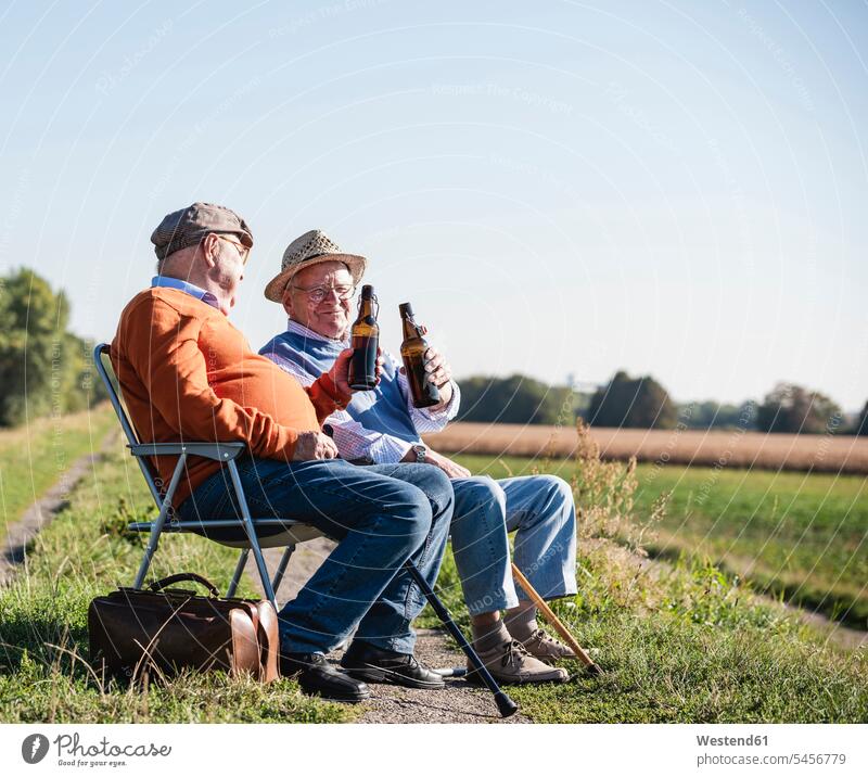 Two old friends sitting in the fields, drinking beer, talking about old times Beer Beers Ale Field Fields farmland Best Friend Best Friends Best Pal speaking