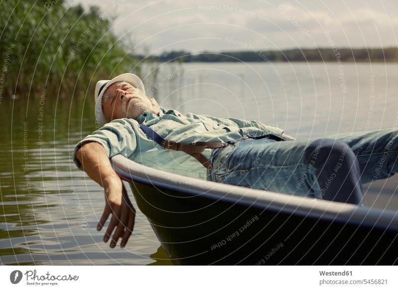 Senior man relaxing in rowing boat on a lake boats lakes relaxation vessel water vehicle waters body of water Brandenburg nonconformity recovering nature