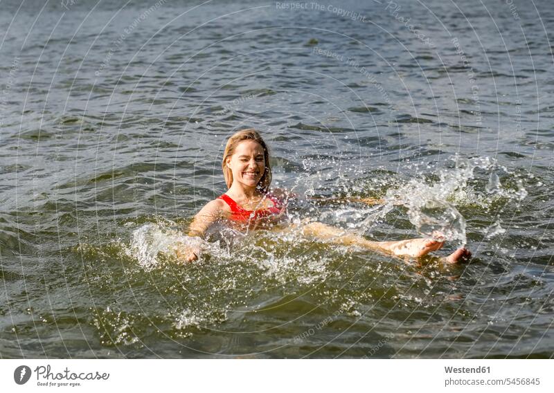 Smiling woman splashing in a lake human human being human beings humans person persons caucasian appearance caucasian ethnicity european 1 one person only