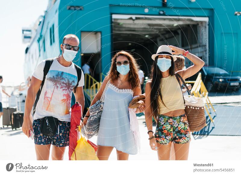 Friends wearing masks standing against cruise ship at harbor color image colour image Spain leisure activity leisure activities free time leisure time