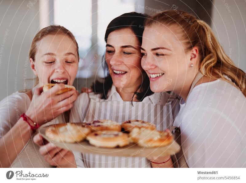 Daughters eating cake, served by their mother bake cook smile delight enjoyment Pleasant pleasure happy pleased at home Alimentation food Food and Drinks