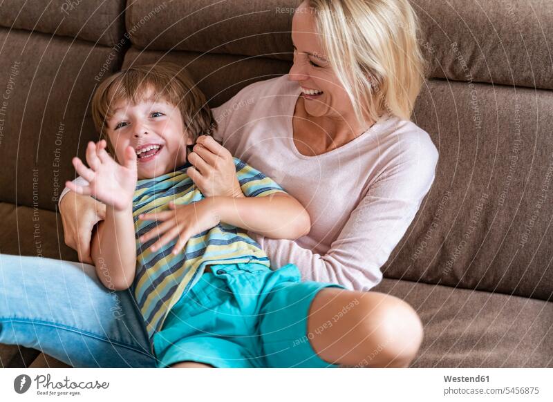 Playful mother and son on couch at home couches settee settees sofa sofas play Ardor Ardour enthusiasm enthusiastic excited relax relaxing relaxation delight