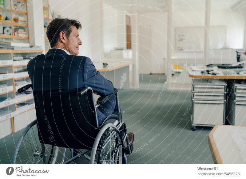 Disabled businessman sitting in wheelchair Success successful thinking Businessman Business man Businessmen Business men office offices office room office rooms