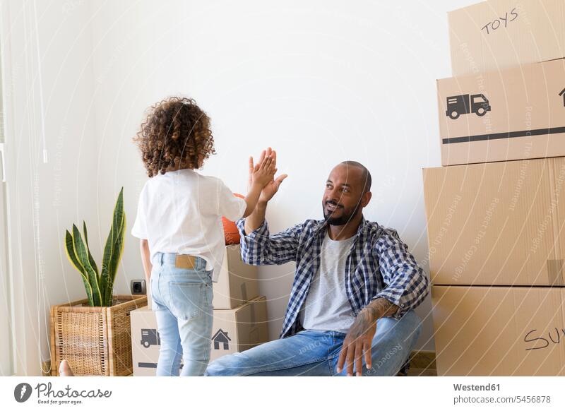 Father and daughter high fiving at new home human human being human beings humans person persons Mixed Race mixed race ethnicity mixed-race Person 2 2 people