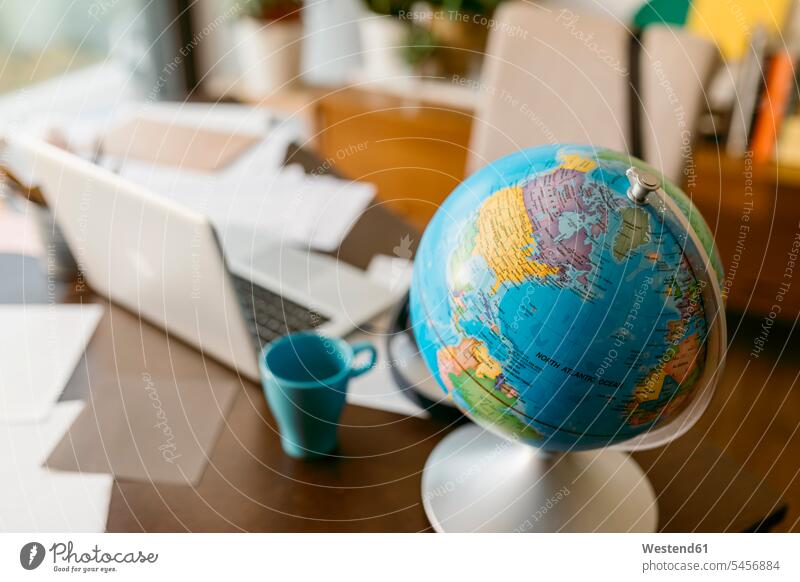 Globe with laptop and mug on table color image colour image indoors indoor shot indoor shots interior interior view Interiors Spain room rooms domestic room