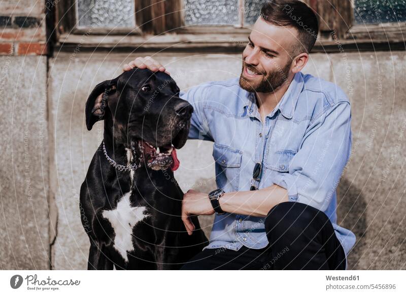 Smiling man stroking his dog outdoors human human being human beings humans person persons caucasian appearance caucasian ethnicity european 1 one person only