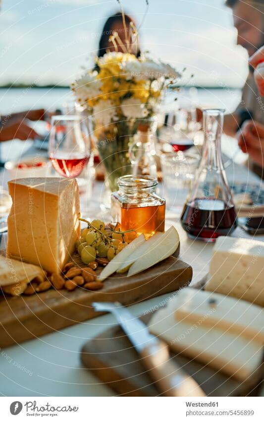 Cheese platter on table with people in background human human being human beings humans person persons caucasian appearance caucasian ethnicity european seasons