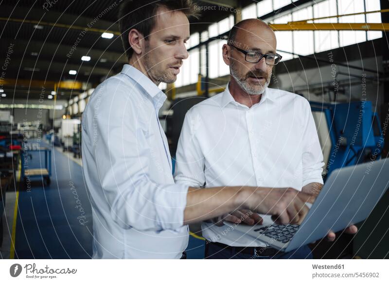 Two men using laptop in a factory human human being human beings humans person persons caucasian appearance caucasian ethnicity european 2 2 people 2 persons