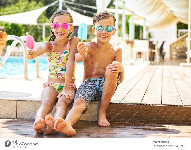 Portrait of happy little girl and boy wearing mirrored sunglasses showing their popsicles human human being human beings humans person persons