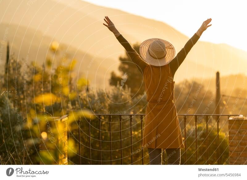 Woman enjoying the view of the sunset in the countryside raising arms, Orgiva, Andalusia, Spain touristic tourists in the evening Late Evening delight enjoyment