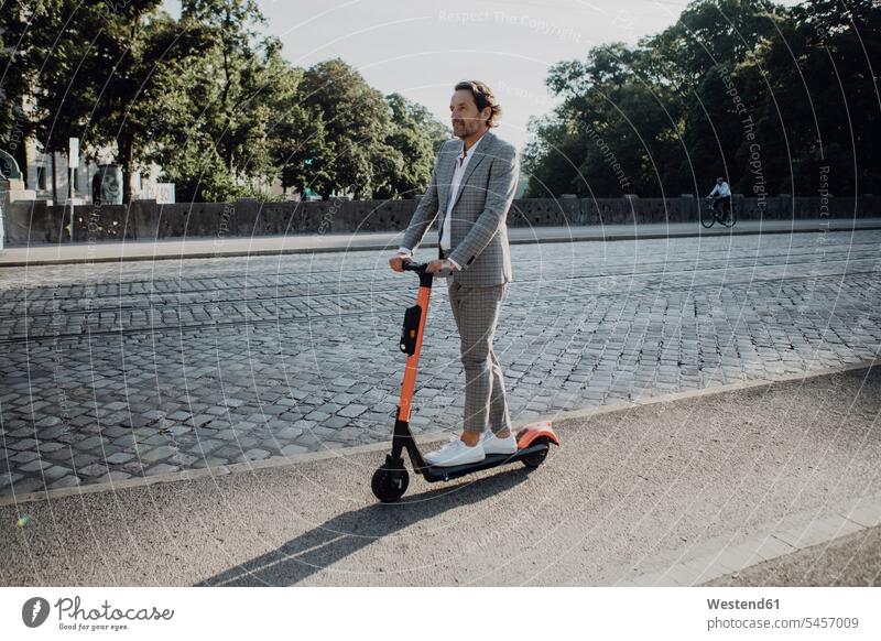 Businessman with e-scooter in the city human human being human beings humans person persons caucasian appearance caucasian ethnicity european 1 one person only