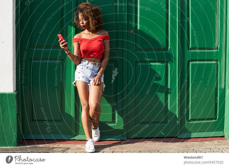 Woman in red checking her phone Afro text messaging SMS Text Message top tops message wireless Wireless Connection Wireless Technology Wireless Communication