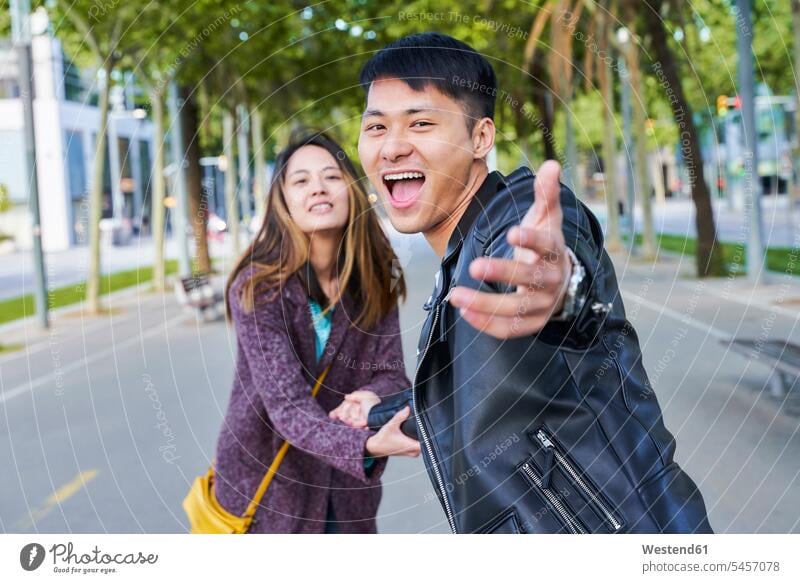 Happy couple inviting someone to join them for a walk, Barcelona, Spain human human being human beings humans person persons Asian Asians Chinese 2 2 people
