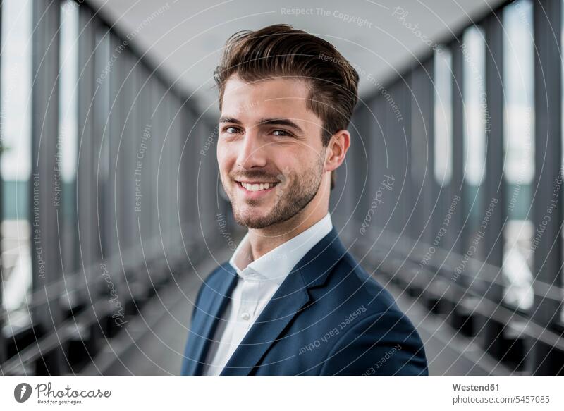 Portrait of smiling young businessman in a passageway portrait portraits smile Businessman Business man Businessmen Business men business people businesspeople