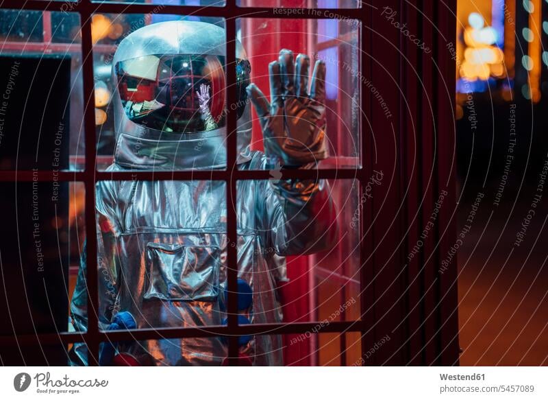 Spaceman standing in a telephone box at night telephone booth telephone kiosk callbox astronaut astronauts by night nite night photography spaceman spacemen