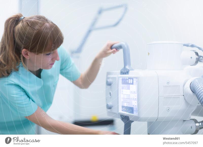 Female radiologist adjusting a x-ray machine human human being human beings humans person persons caucasian appearance caucasian ethnicity european 1